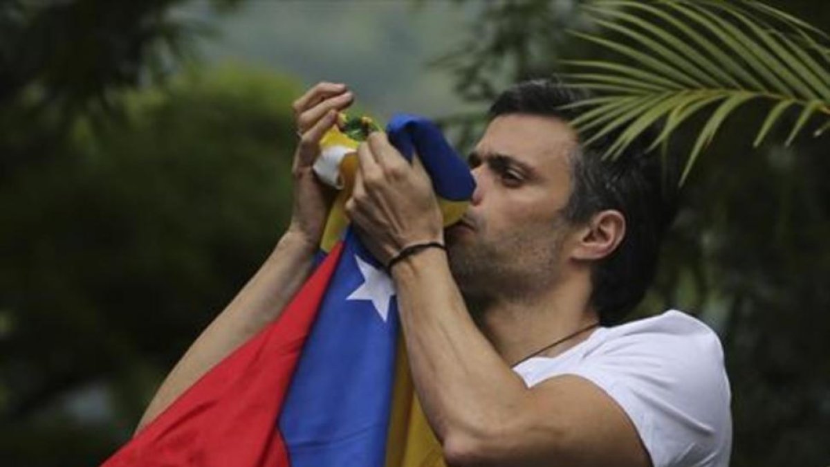 Leopoldo López besa la bandera venezolana tras ser liberado.-AP / ARIANA CUBILLOS