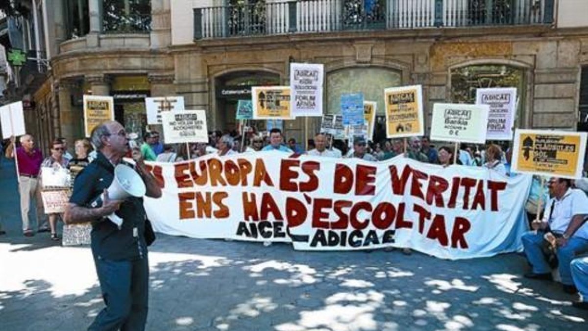 Concentración de afectados por preferentes y cláusulas suelo convocada por Adicae ante la sede de la UE en Barcelona.-RICARD CUGAT