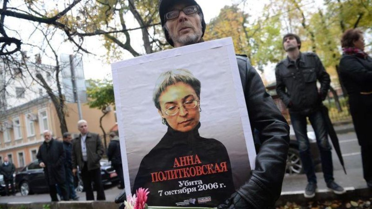 Un hombre sostiene una foto de Politkóvskaya en una concentración en su recuerdo el viernes en Moscú.-AFP / NATALIA KOLESNIKOVA