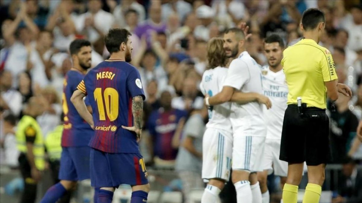 Benzema es felicitado por su gol, con Messi como testigo.-JOSE LUIS ROCA