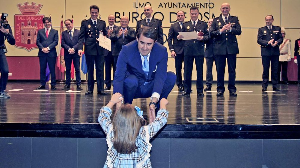 Suárez-Quiñones aupa a una niña que reclamó en voz alta a su "papá" condecorado.-MARIO TEJEDOR