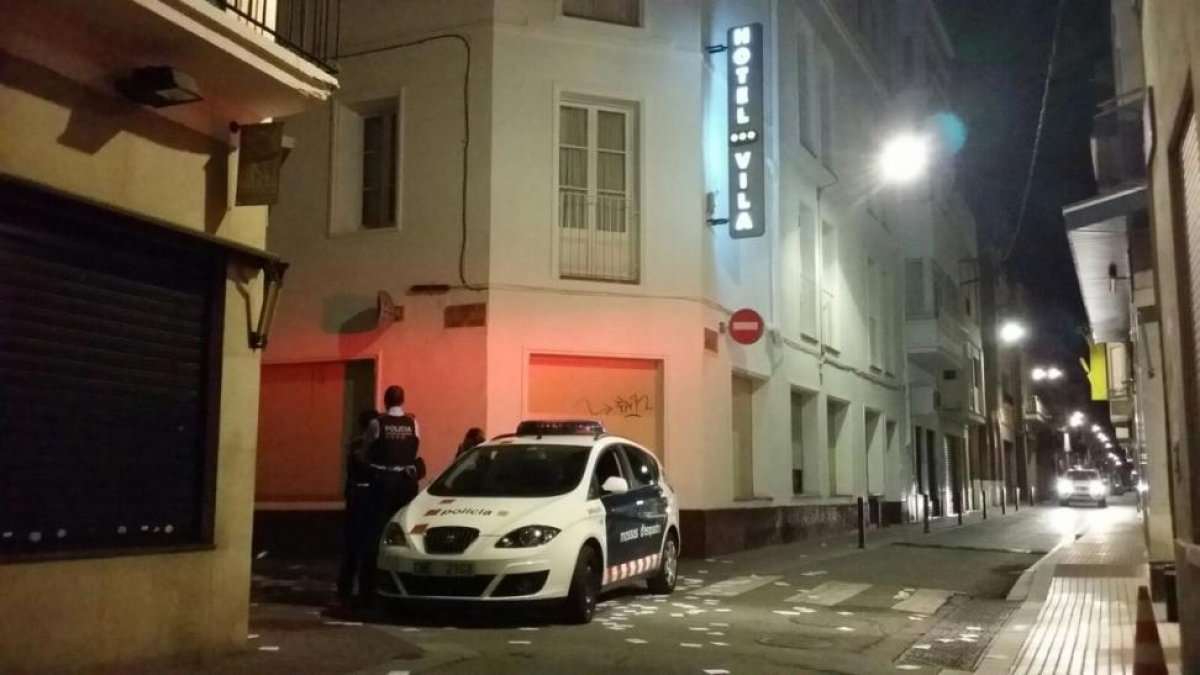 Una patrulla de los Mossos vigila la calle de Sant Josep, donde está el hotel Vila. En el suelo, papeletas de votación.-ÓSCAR HERNÁNDEZ