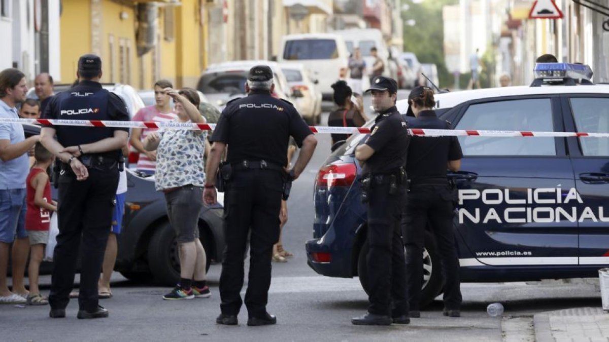 EFE / JOSÉ MANUEL VIDAL  Agentes de policía y vecinos, frente al domicilio donde un hombre ha matado a su expareja, en Sevilla.-EFE