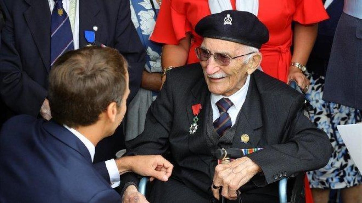 Macron saluda a un veterano durante la ceremonia de conmemoración en Portsmouth, Reino Unido.-EFE / OWEN COOBAN