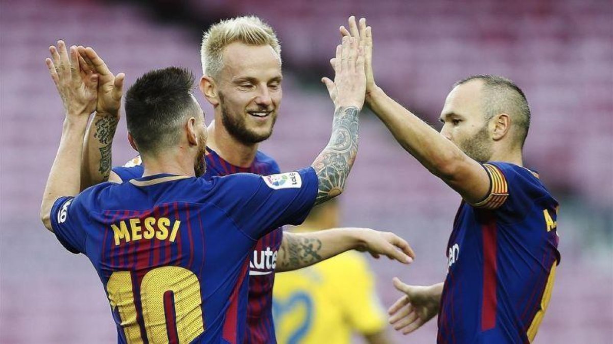 Rakitic e Iniesta felicitan a Messi tras uno de sus goles al Las Palmas.-EFE / ALEJANDRO GARCÍA