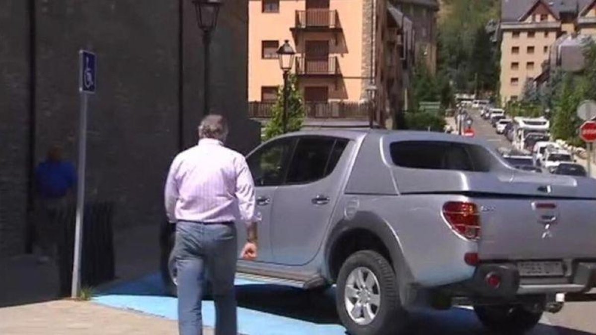 Luis Bárcenas se dirige a su vehículo, aparcado en una plaza para discapacitados, tras acudir a firmar a los juzgados de Vielha, este martes.-TV-3