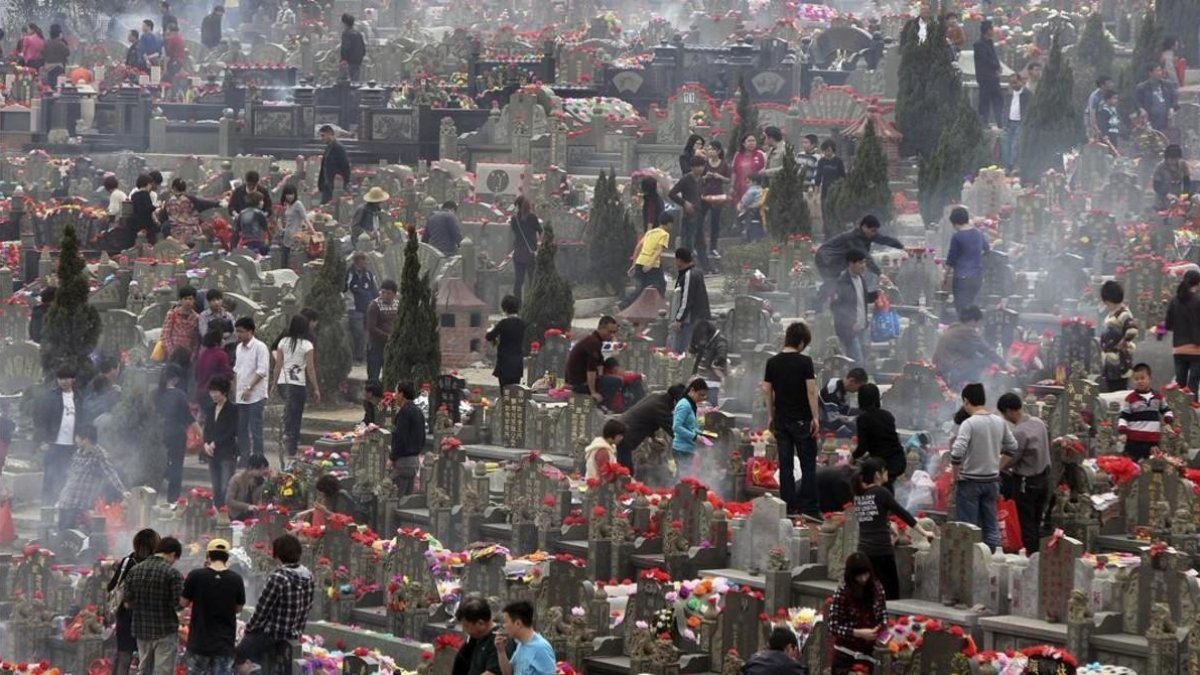 Familiares visitan las tumbas de sus seres queridos en un cementerio de la ciudad china de Jinjiang.-AP