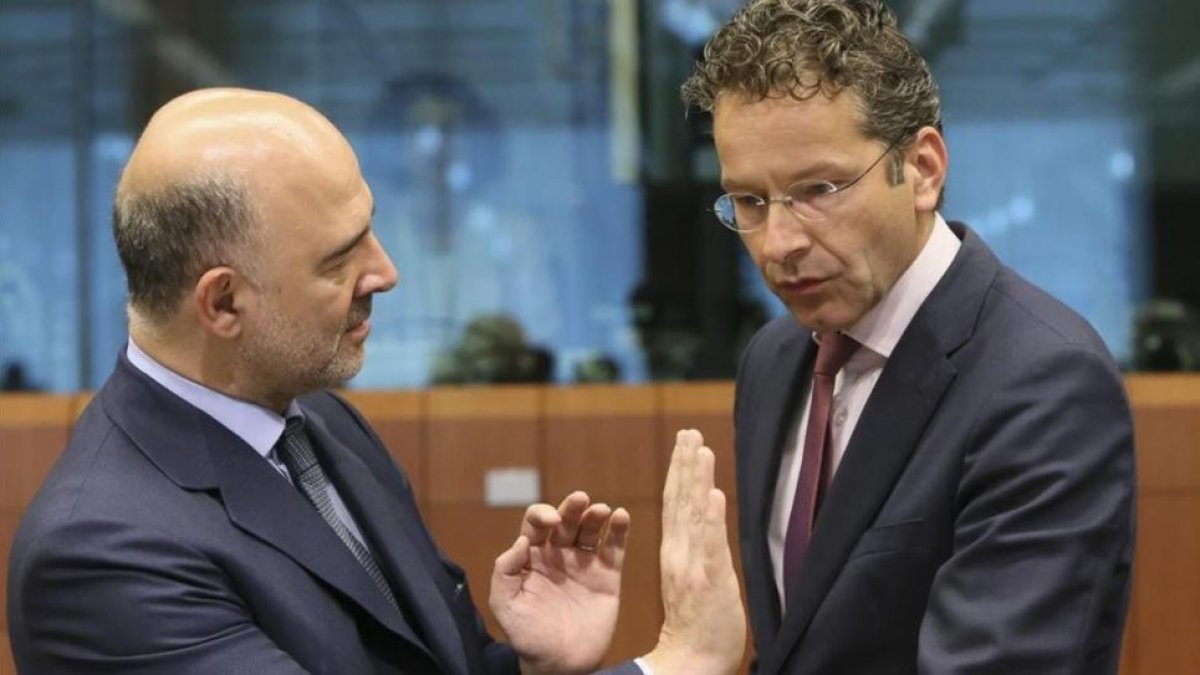 Dijsselbloem, derecha, con el comiario europeo de Asuntos Economícos, Pierre Moscovici, en este lunes en Bruselas.-OLIVIER HOSLET