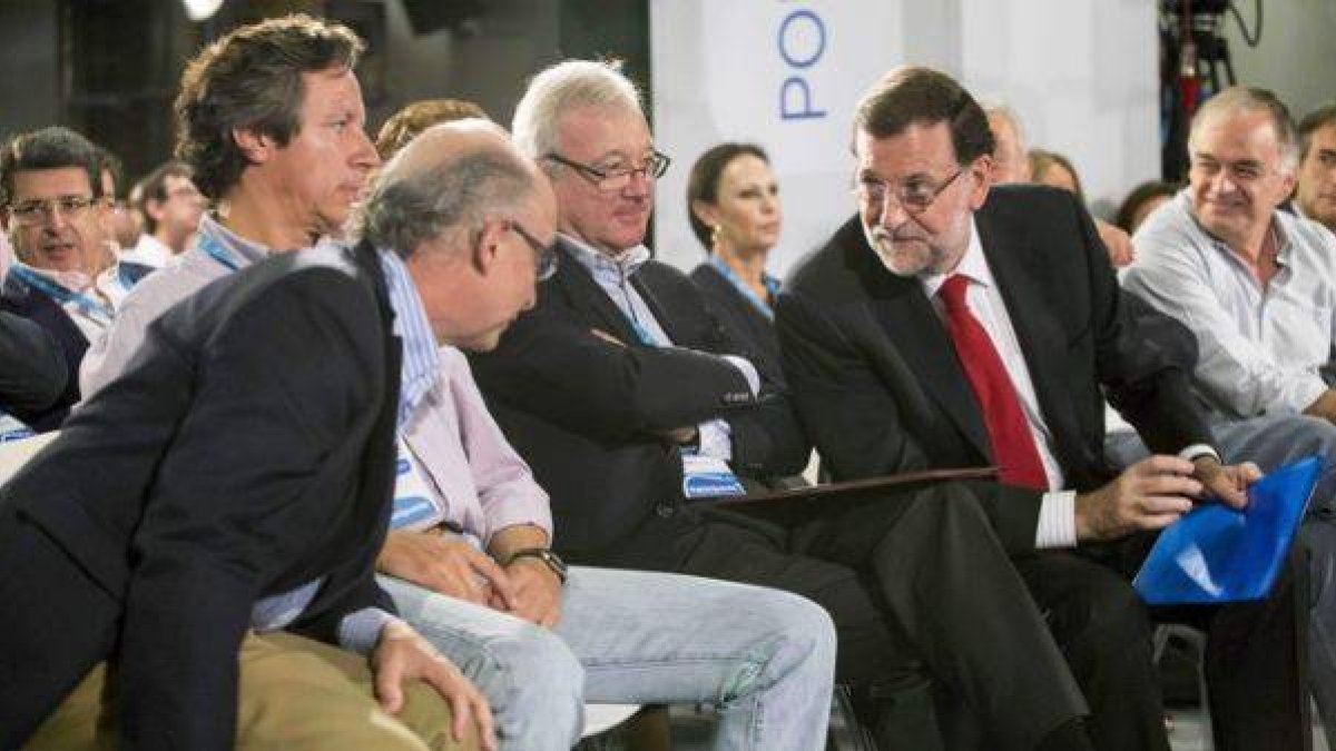Rajoy habla con Cristóbal Montoro ante el presidente del PP de Murcia, Ramón Luis Valcárcel, y Carlos Floriano, durante la Intermunicipal del PP, este domingo en Murcia.-Foto: EFE / MARCIAL GUILLÉN