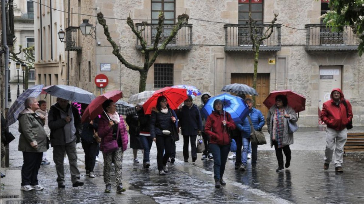 Un grupo de personas pertrechadas bajo sus paraguas en la calle Aduana Vieja.-VALENTÍN GUISANDE