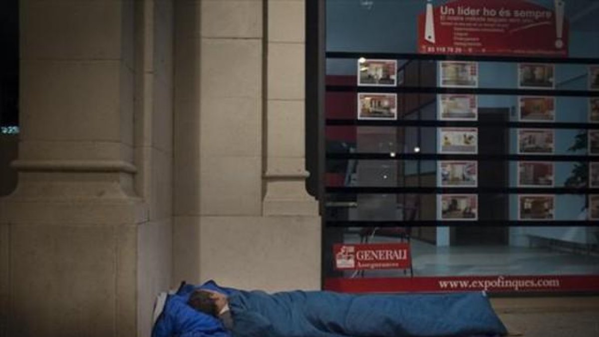 Un hombre duerme en el paseo de Picasso, en Barcelona, a principios de este año.-CARLOS MONTAÑÉS