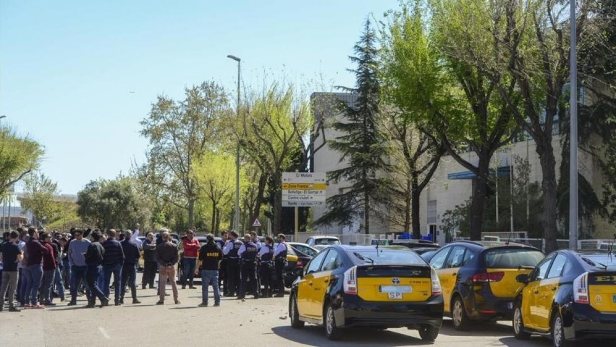 Medio centenar de taxistas se manifiestan contra el intrusismo laboral ante una de la sede de Cabify en L'Hospitalet, una de las empresas que presta servicios de VTC.-JORDI COTRINA