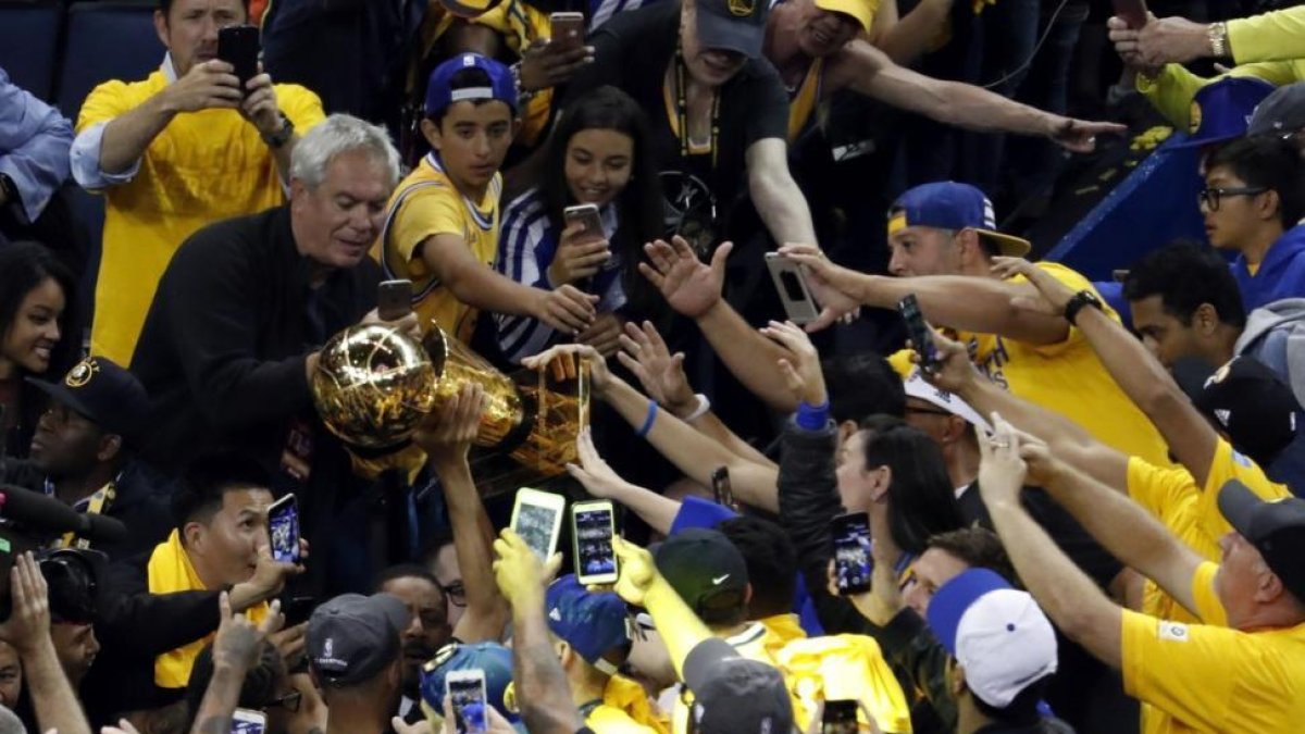 Stephen Curry alza el trofeo de la NBA.-EFE