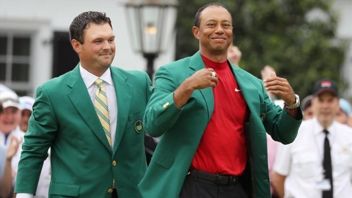 Tiger Woods recibe la chaqueta verde del anterior ganador Patrick Reed en la ceremonia del Masters.-LUCY NICHOLSON (REUTERS)