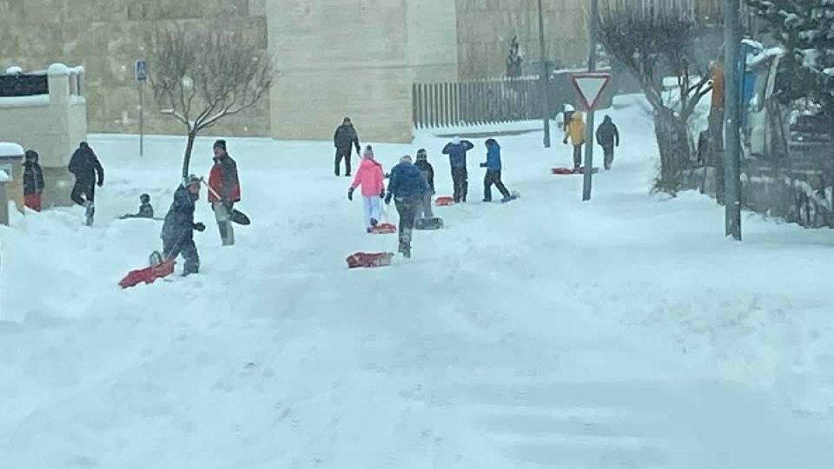 Niños y algunos mayores aprovechando la nieve para jugar en Golmayo, donde la población contribuyó a limpiar las calles con el Ayuntamiento.-HDS