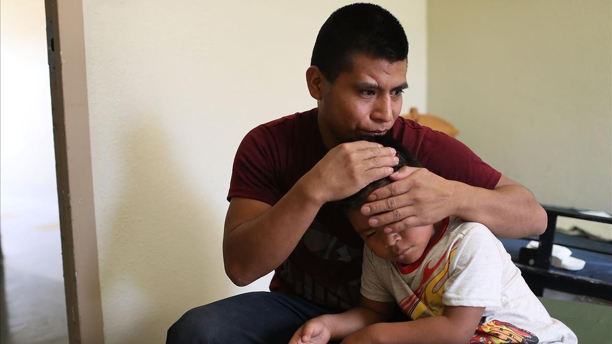 Un inmigrante centroamericano abraza a su hijo después de que lograran reunirse en El Paso, Texas.-AFP / JOE RAEDLE