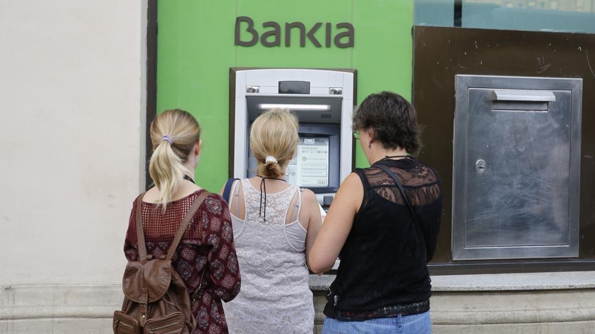Usuarios de Bankia utilizan un cajero de la entidad en Barcelona.-EL PERIÓDICO / ARCHIVO