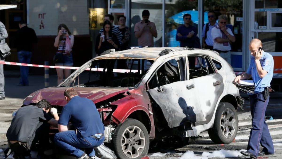 Agentes inspeccionan el coche en el que viajaba el periodista Pavel Sheremet, este miércoles en Kiev.-REUTERS / VALENTYN OGIRENKO