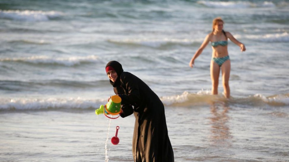 Una musulmana se baña con el hiyab en la playa en Tel Aviv.-BAZ RATNER / REUTERS