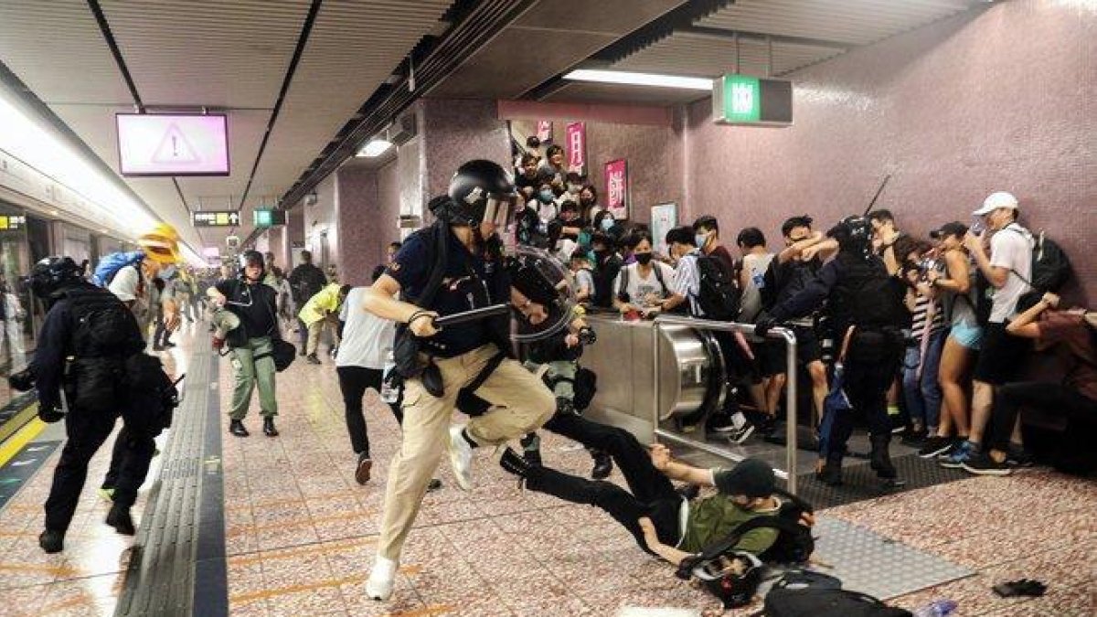 Agentes de policía cargan contra ciudadanos que venían de la manifestación, en la estación de metro Prince Edward de Hong Kong, este sábado.-AP / HK01