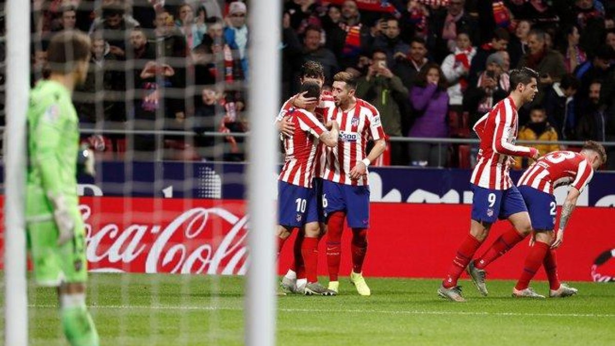 Los jugadores del Atlético celebran un gol ante la desolación del portero del Levante Aitor Fernández.-EFE