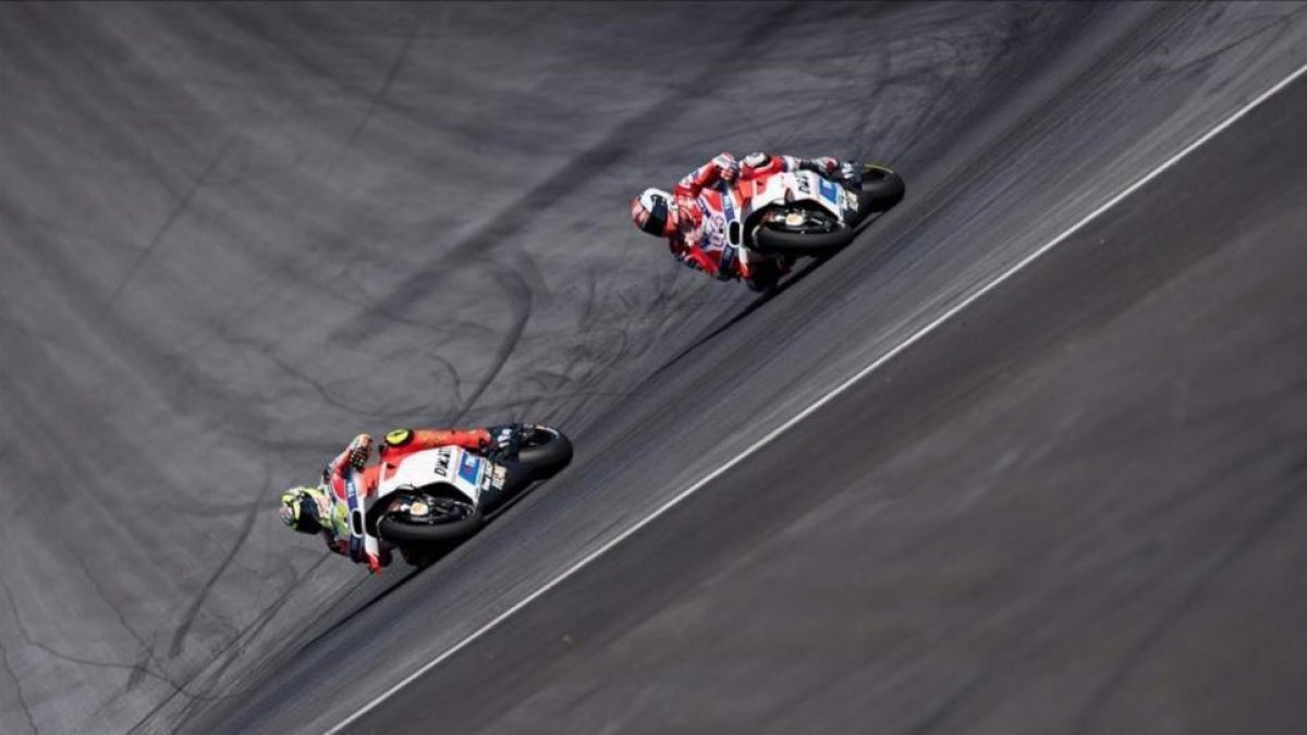 Andrea Iannone (izquierda) traza una curva por delante de su compañero en Ducati Andrea Dovizioso, durante el GP de Austria de MotoGP.-AFP / JOE KLAMAR