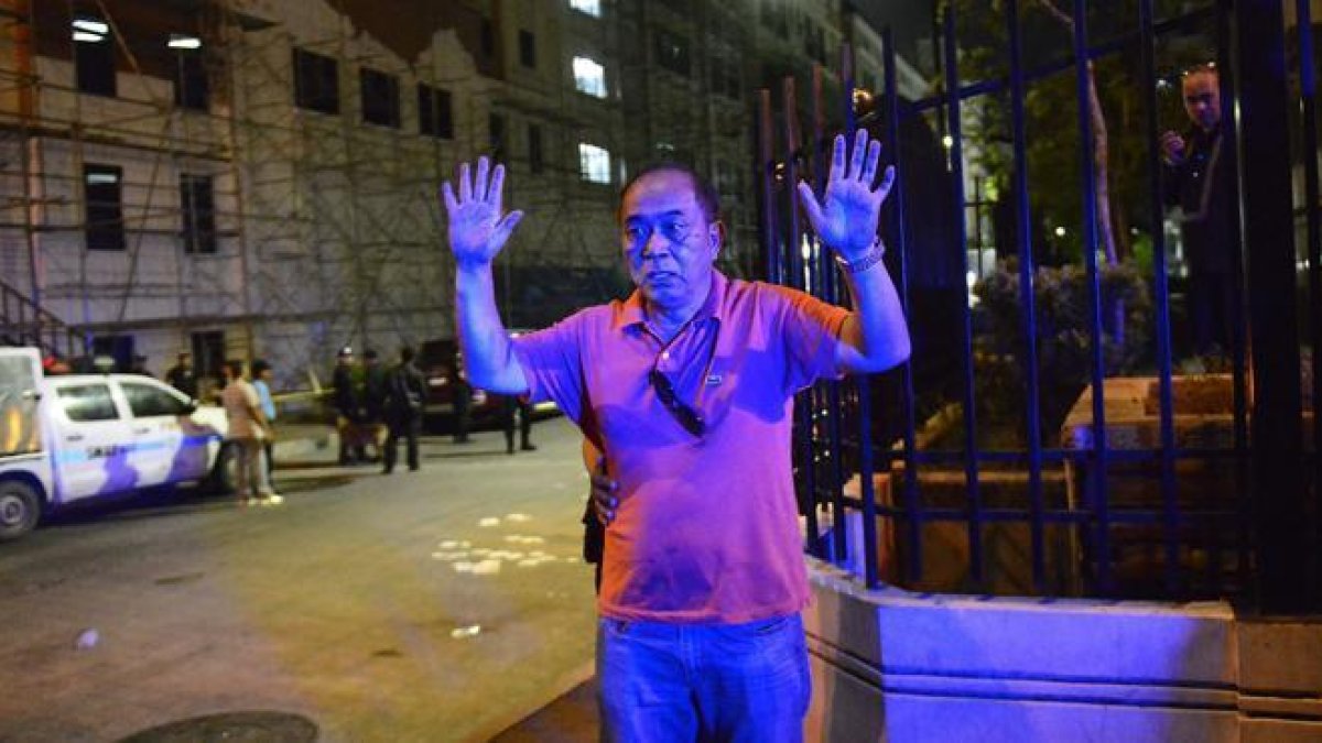 Agentes de la policía filipina, identifican a los ciudadanos junto al hotel atacado en Manila.-EFE