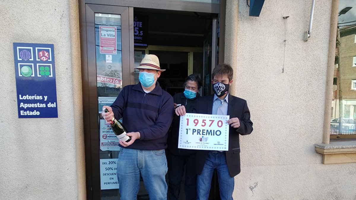 Los responsables de la Droguería La Villa celebran en la puerta del establecimiento la venta de un décimo  del Gordo. A. CARRILLO