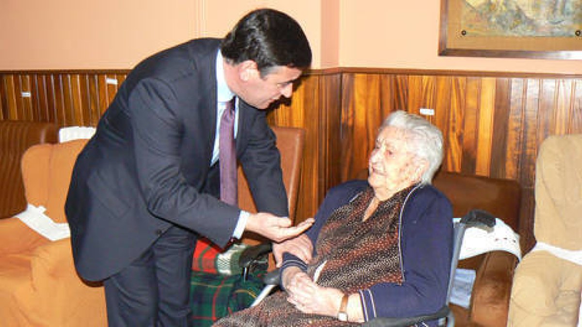 Pardo dialoga con una anciana durante su visita a Los Milagros. /EVA SÁNCHEZ-