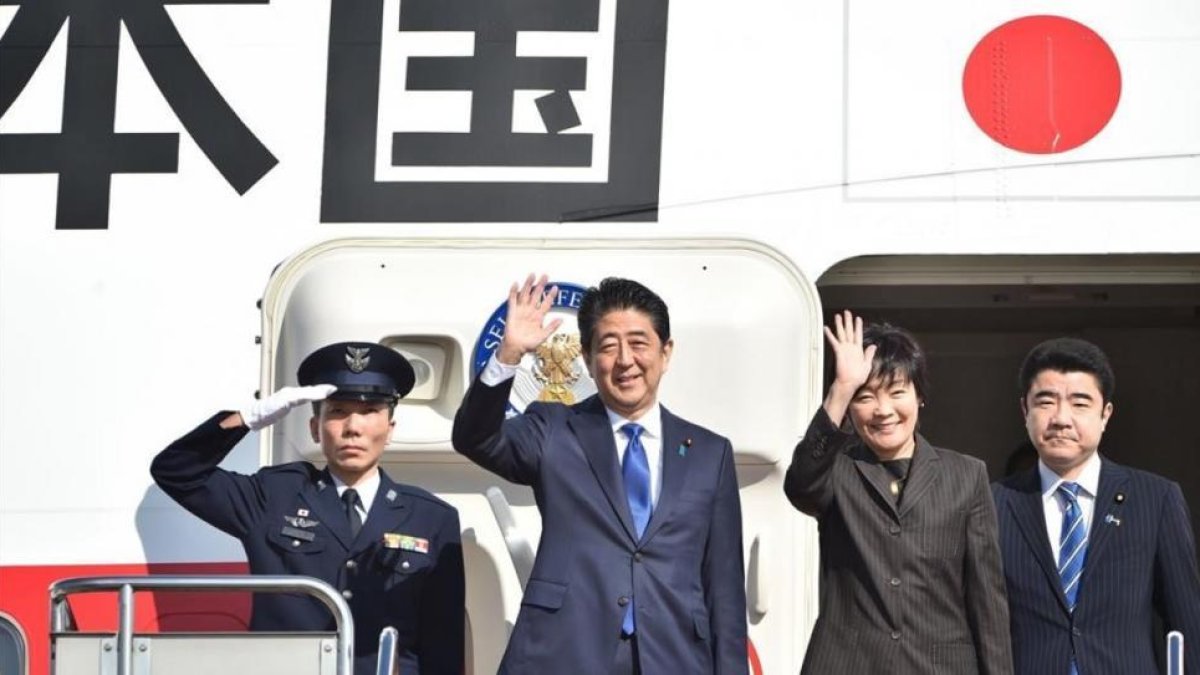 Abe (segundo por la izquierda) y su esposa, Akie, saludan antes de embarcarse en el avión hacia EEUU, en el aeropuerto de Haneda (Tokio), este jueves.-AFP / KAZUHIRO NOGI