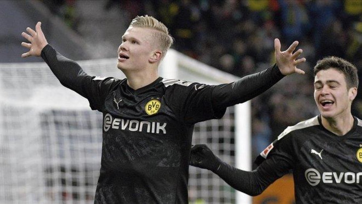 Erling Haaland celebra su tercer gol al Augsburgo en su debut liguero con el Dortmund.-AP