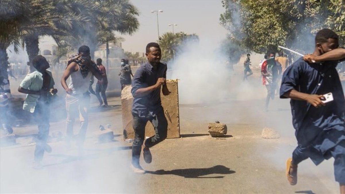 Manifestantes se protegen de los gases lacrimógenos de las fuerzas de seguridad en Jartum.-EFE