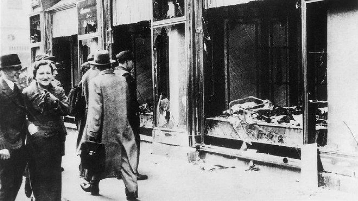 Transeúntes indiferentes ante una tienda judía destruida y saqueada en la Alemania nazi.-ARCHIVO