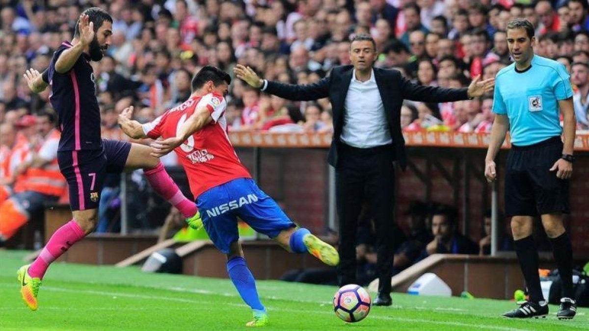 Arda Turan y Sergio Álvarez luchan por un balón delante de Luis Enrique en El Molinón.-AFP / ANDER GILLENEA