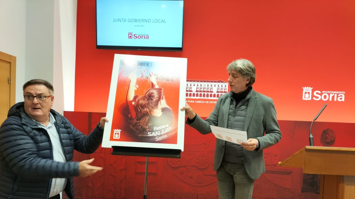 José Luis Ruiz y Carlos Martínez sostienen el cartel anunciador de San Juan 2023 en Soria. J.A.C.