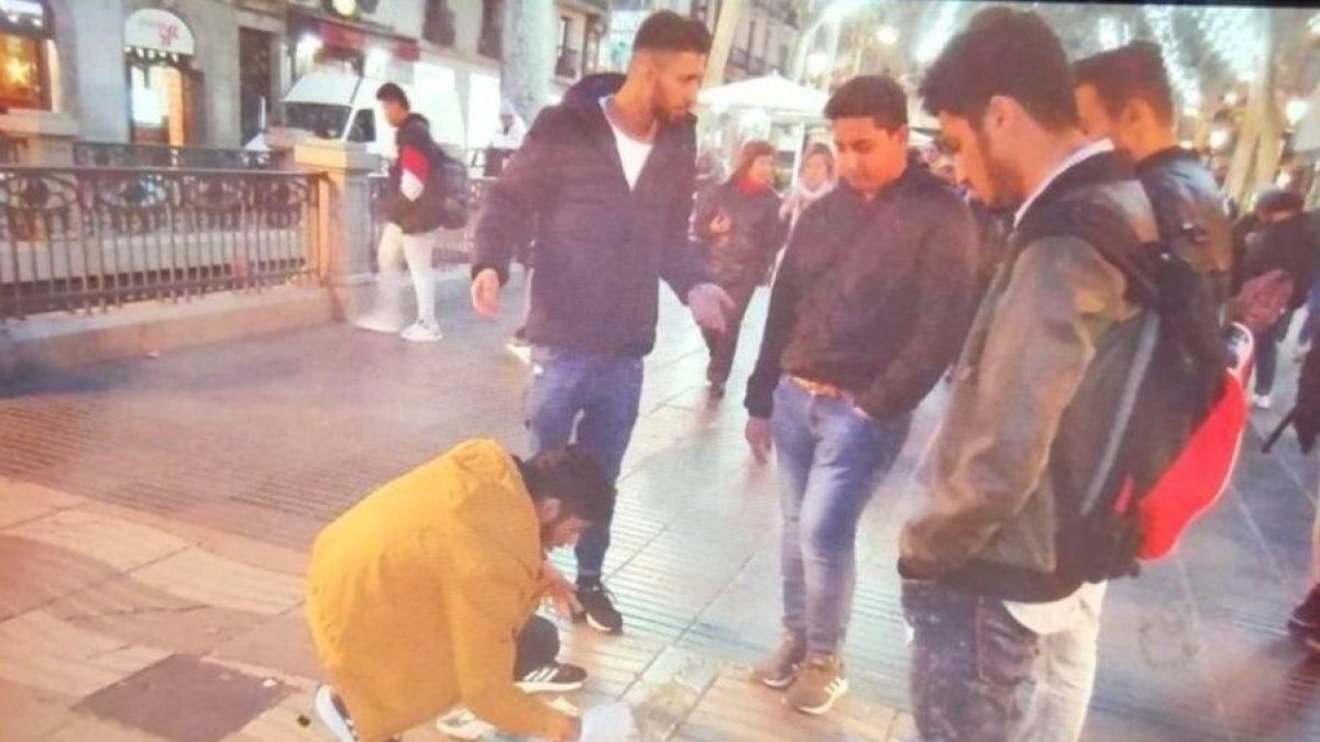 Momento en que unos hombres tapan con cemento la inscripción en árabe del memorial por las víctimas del 17-A.-CPU POLICÍAS UNIDOS