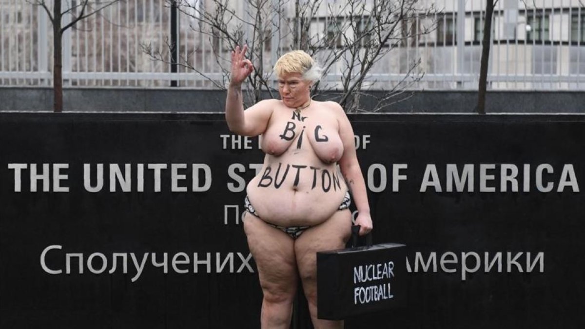 Una activista del movimiento Femen parodia a la mención de Trump sobre el tamño de su botón nuclear, ante la embajada de EEUU en Kiev (Ucrania).-/ AFP / SERGEI SUPINSKY