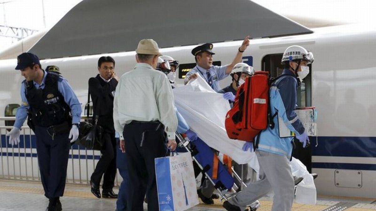 Un pasajero herido al suicidarse un individuo en un tren bala japonés es trasladado por los equipos de emergencia.-Foto: REUTERS / TORU HANAI