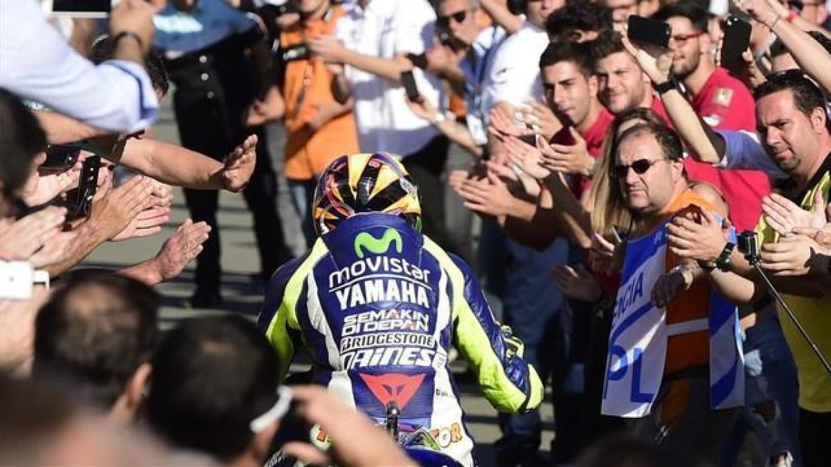 Valentino Rossi se dirige a su box entre aplausos de los aficionados tras acabar cuarto en el GP de la Comunitat Valenciana.-AFP / JOSÉ JORDÁN