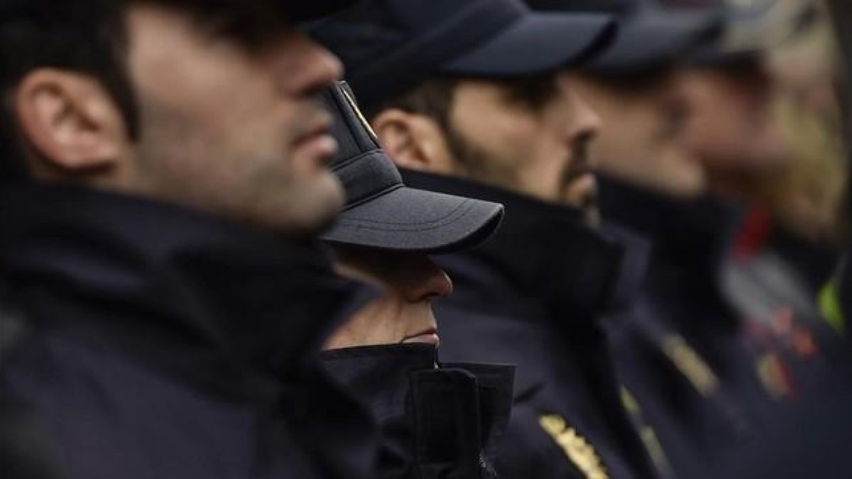 Agentes de la policía guardan un minuto de silencio en memoria de los dos policías asesinados el viernes en Afganistán.-AP / ALVARO BARRIENTOS
