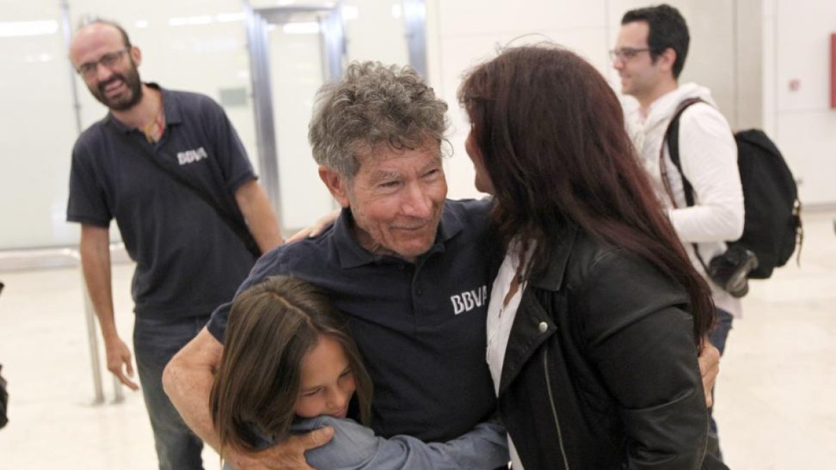 El alpinista abulense, Carlos Soria, es abrazado por su nieta y su hija a su llegada al aeropueto de Madrid después de su cumbre en el Annapurna.-ICAL