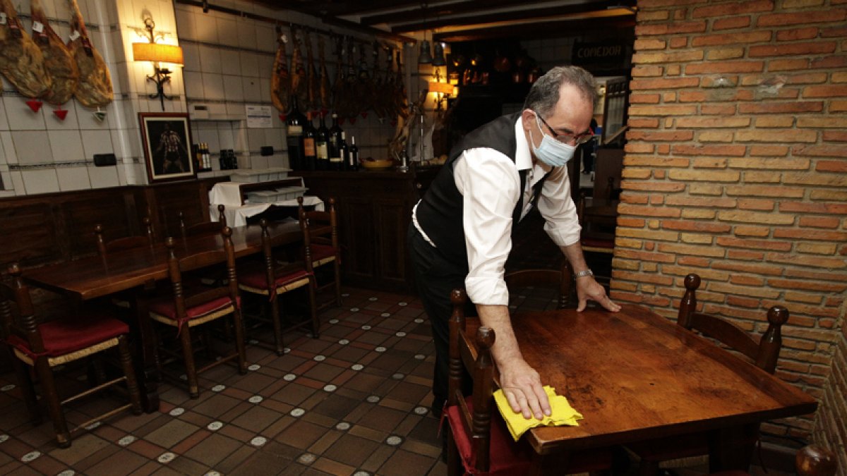 Camarero limpiando un bar en la capital.-HDS
