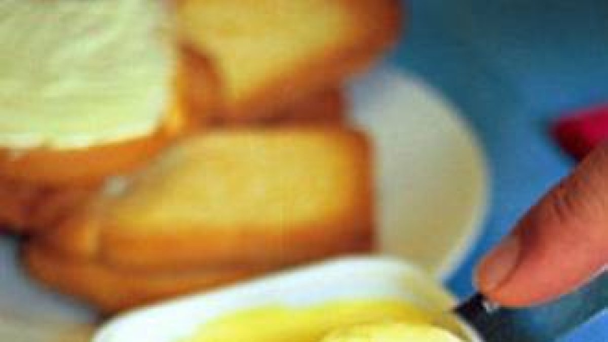 Una persona se prepara una tostada con mantequilla.-Foto: MAITE CRUZ