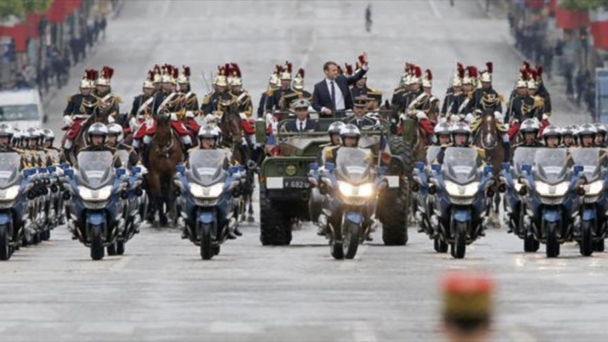 Macron saluda desde un vehículo militar a su paso por los Campos Elíseos.-MICHEL EULER