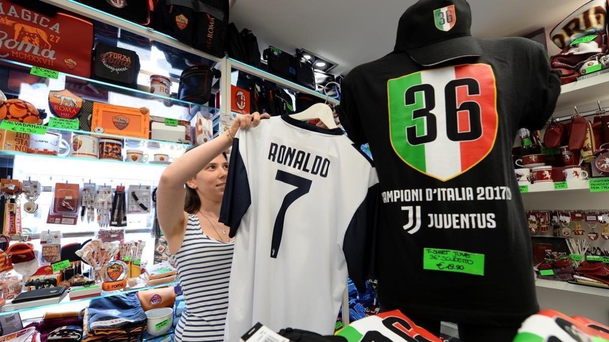 Una vendedora coloca una camiseta de Cristiano con el 7 de la Juventus.-REUTERS / MASSIMO PINCA