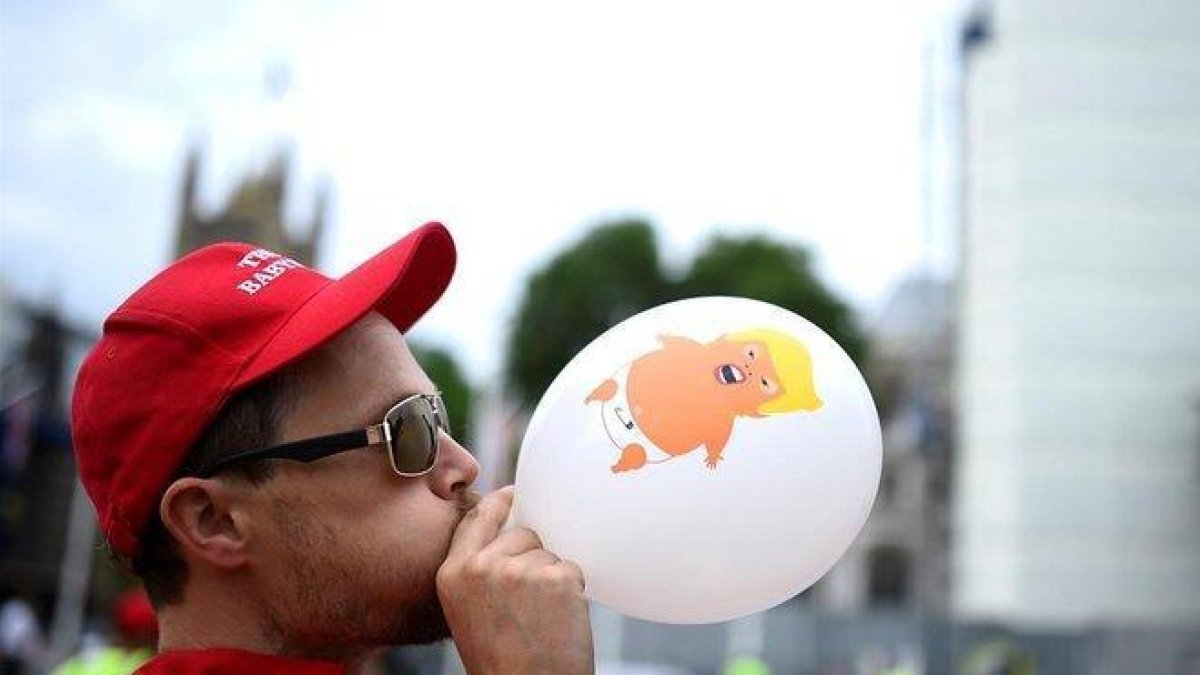 Un manifestante hincha un globo con la imagen del baby Trump, este martes en Londres.-CLODAGH KILCOYNE (REUTERS)