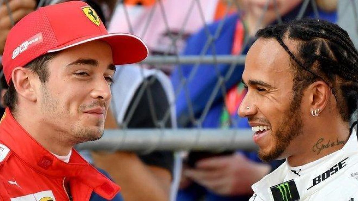 Charles Leclerc y Lewis Hamilton conversan tras el último ensayo de Sochi, donde el joven monegasco ha logrado la ’pole’.-AFP