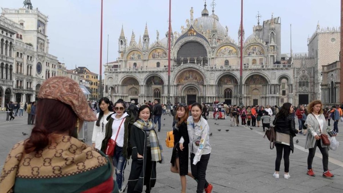 Turistas se hacen fotos frente a la catedral de San Marco, en Venecia, el 20 de octubre.-/ AFP / MIGUEL MEDINA