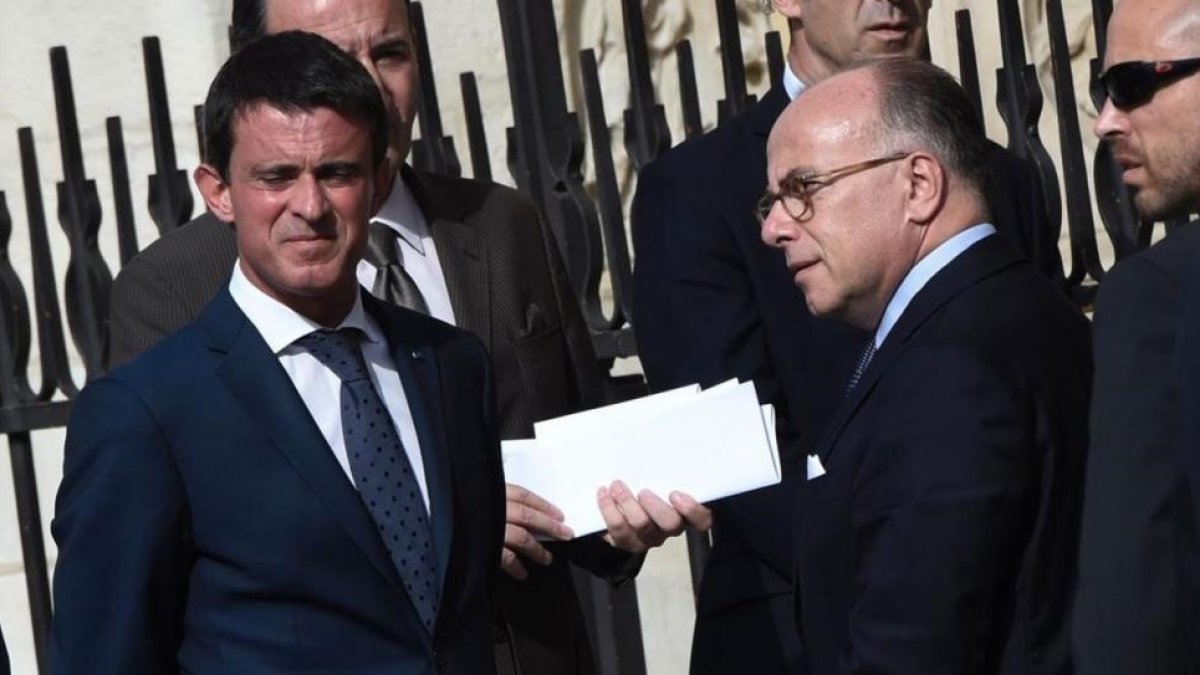 Valls (izquierda) junto al ministro de Interior, Bernard Cazeneuve, a su llegada a la catedral de Notre Dame, en París, el 27 de julio.-AFP / DOMINIQUE FAGET