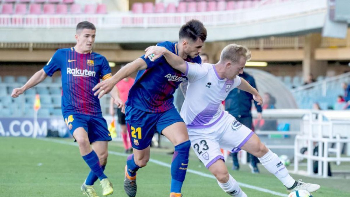 Dani Nieto protege el balón ante Costas durante el partido disputado ayer en Barcelona.-AREA 11